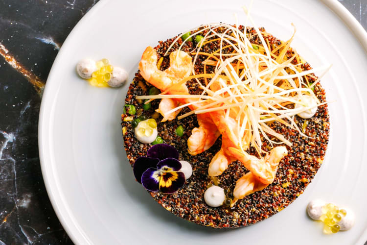 A quinoa and shrimp dish with edible flowers