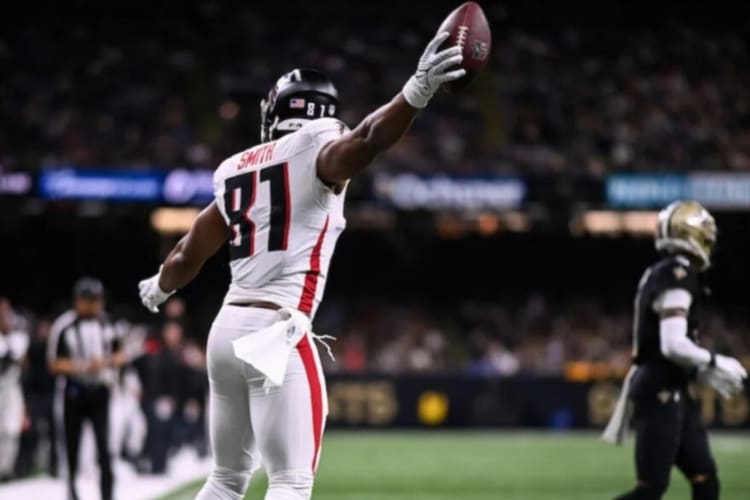 A football player in a stadium catching a football