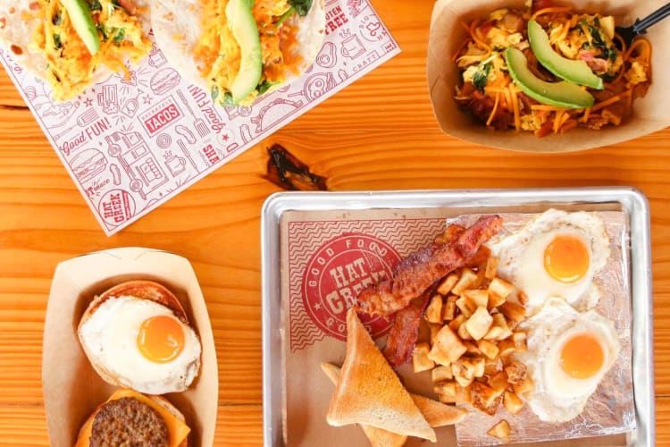 Breakfast dishes on trays and patterned paper on a table