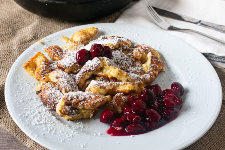Kaiserschmarrn on a white plate with poached berries