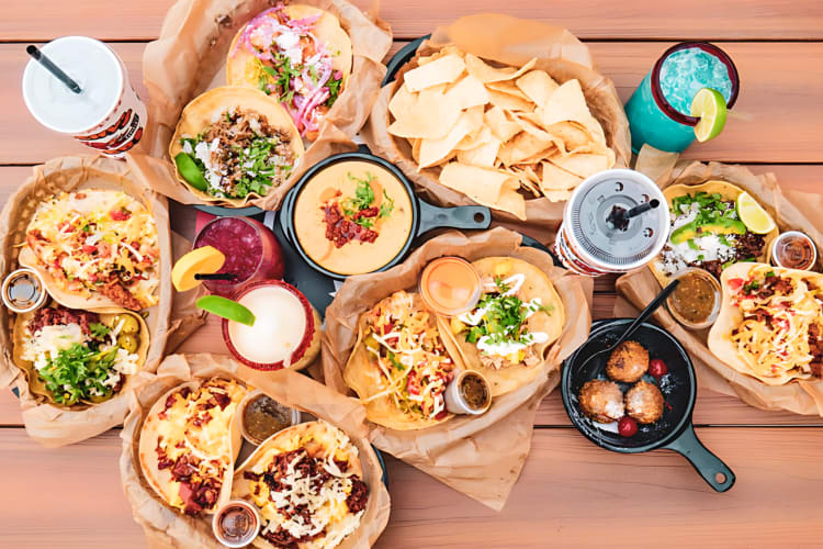 A variety of items from this fast food restaurant in Austin, including burritos, tacos, nacho's and drinks.  