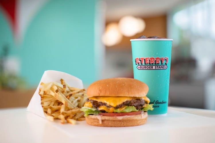 A juicy cheese burger with fries and a coke. 