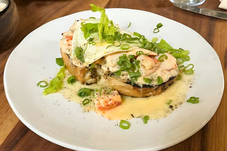 Lobster toast with fried eggs and chives. 