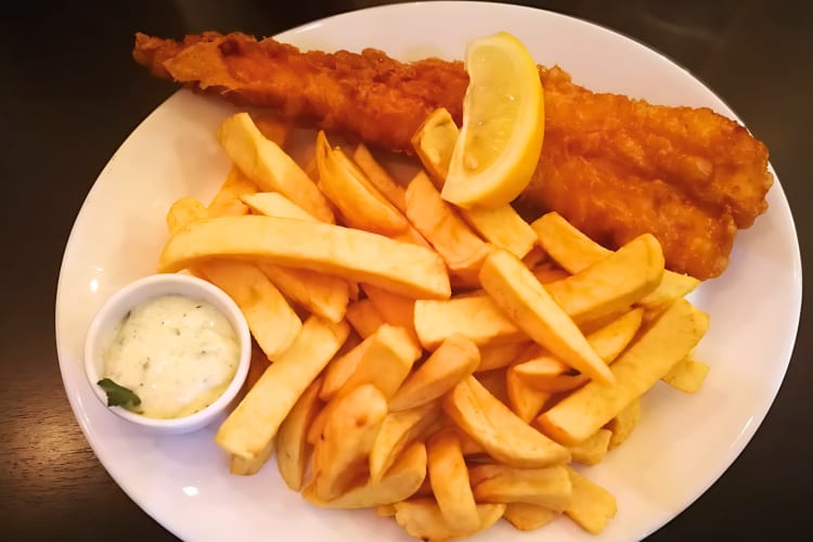 classic London fish and chips with a side of sauce. 