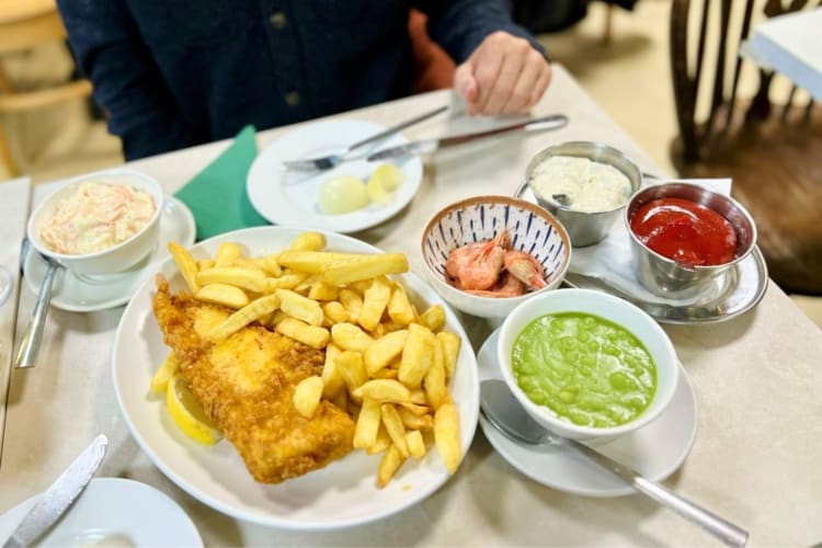 Cod fish & chips, mushy peas and coleslaw are available at this fish and chip shop in London 