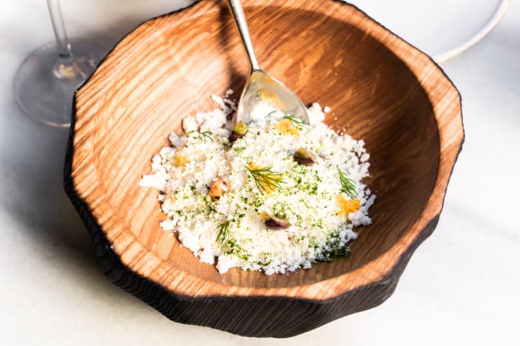 Couscous with mushrooms and peppers in a wooden bowl can be found at this Michelin restaurant in Barcelona. 
