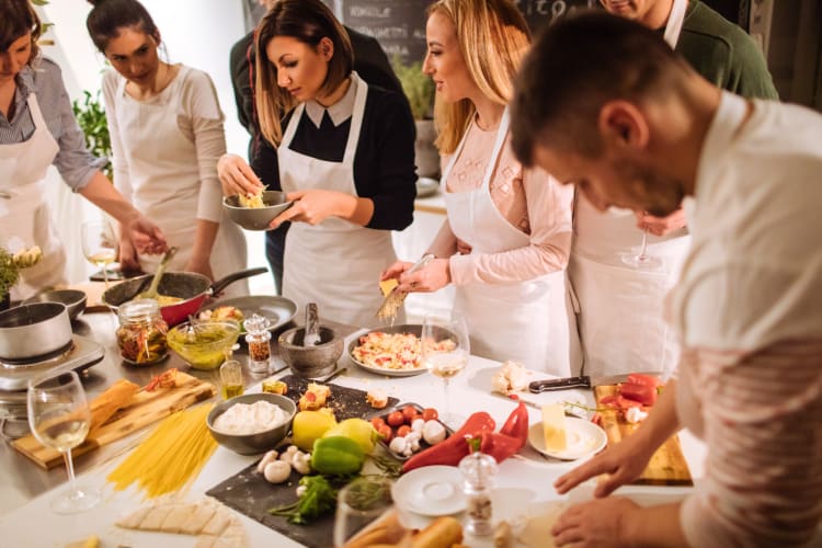 A group of people in a cooking class learning how to cook with jalapeño peppers.