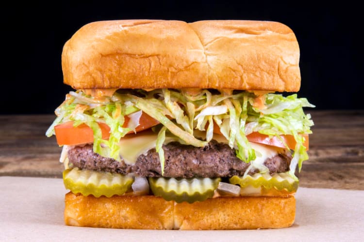 At this fast food Chicago spot you can get this huge cheeseburger with cheese, onions, tomatoes and pickles. 