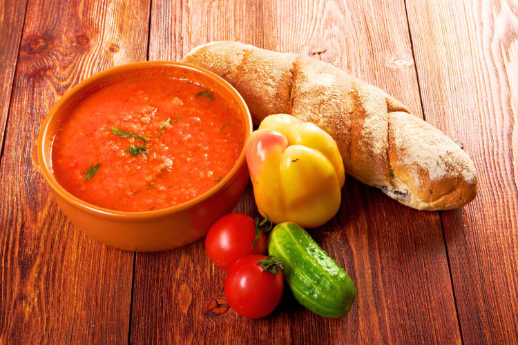 Pappa al Pomodoro is a Florence food made of tomatoes. This dish is served in an orange bowl with bread and peppers on the side. 