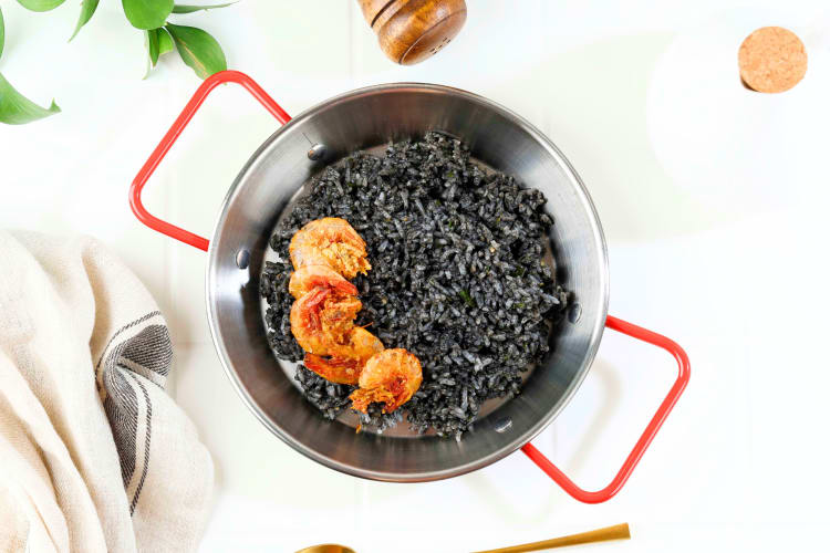 This Barcelona food combines tender squid with uniquely colored rice and is often accompanied by a side of aioli.