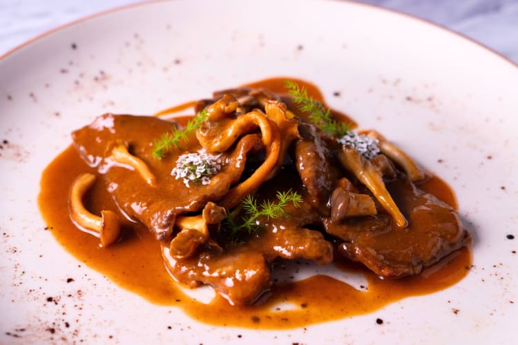 This Barcelona food contains tender veal slices simmered in a savory sauce with seasonal mushrooms.