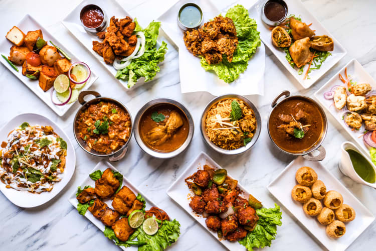 A variety of Indian dishes including multiple curries and bhaji.