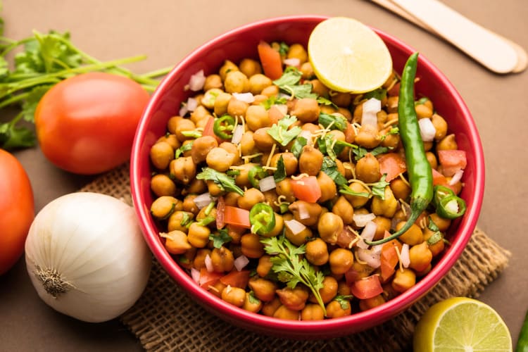 This North Indian dish is chickpea curry served in a red bowl 