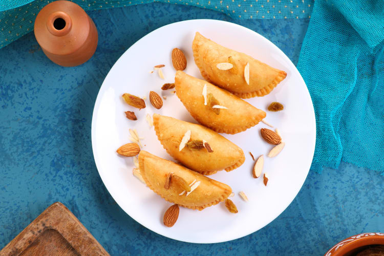 This North Indian food is stuffed with sweet mixes of nuts and dried fruit, then pinched in a semicircle, sealed with a fluted edge and fried until crispy.