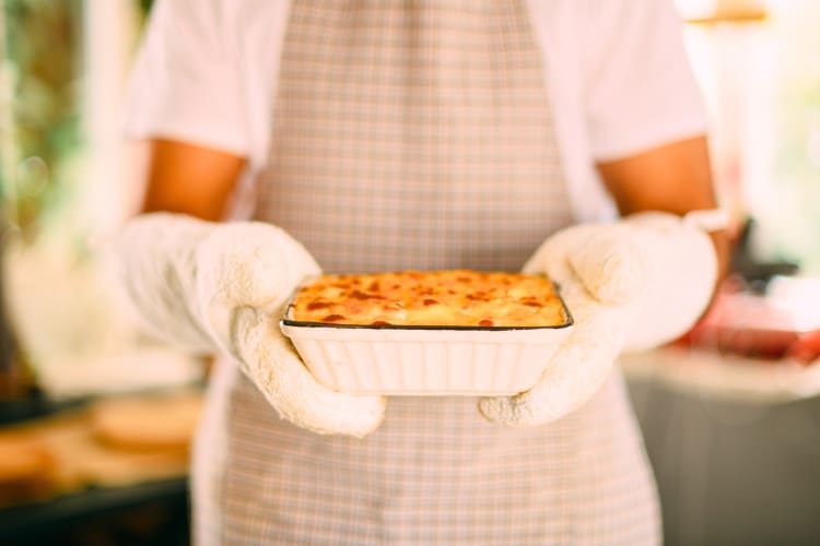 A person holding had made mac and cheese that can be easily frozen. 