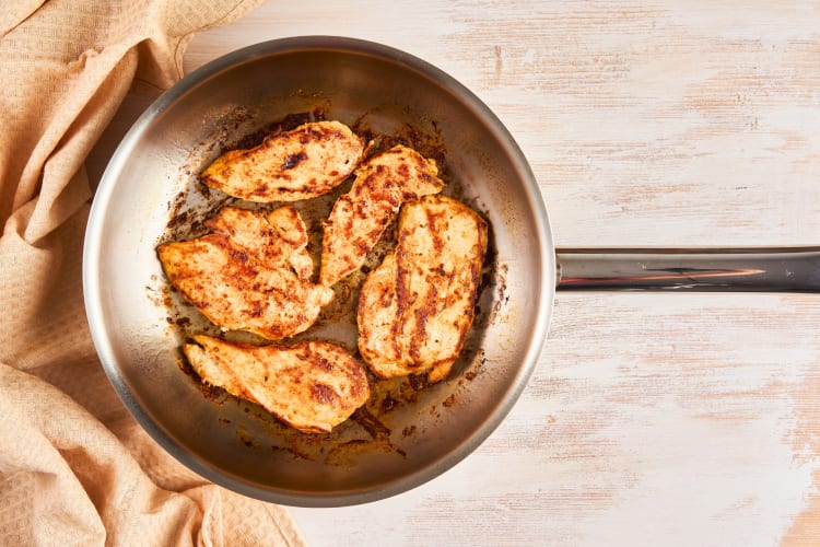 This is a stainless steel skillet that has been used to fry up chicken breast. 