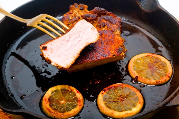 Skillet pork chops cooked with oranges in a skillet. 