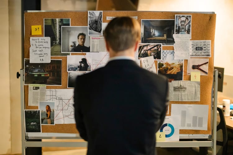 A person standing in front of a board of evidence while taking part in a team building activity in Belfast. 