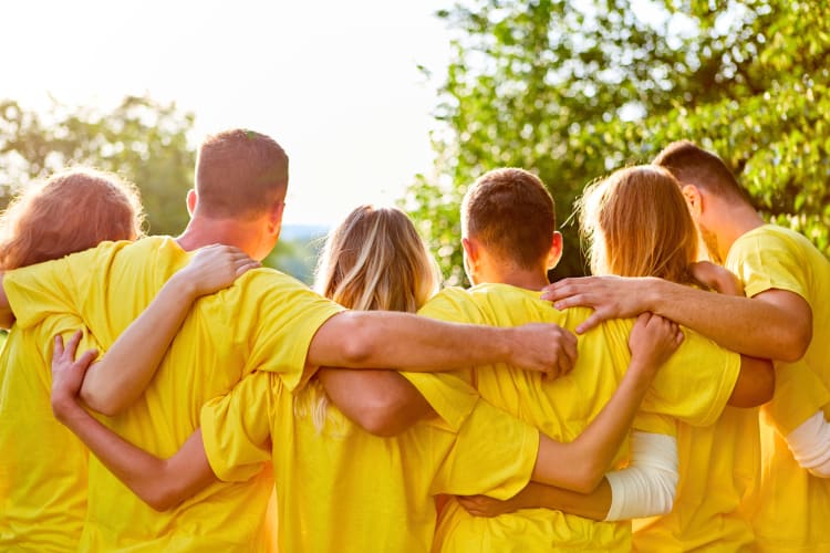 A group of people in yellow shirts who have benefited from team building activities in Belfast. 