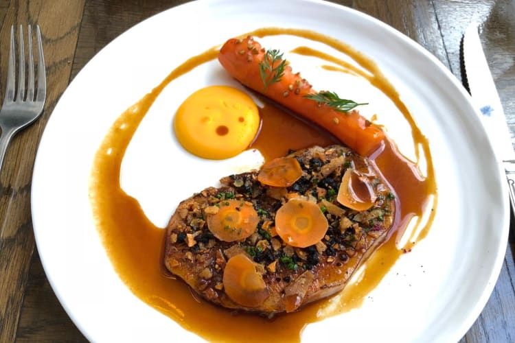 At this Michalin star restaurant in London, try this braised steak with carrots and sauce. 