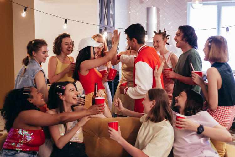 a group of men and women laugh and high five