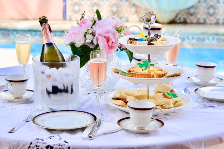 An afternoon tea setup with cakes and Champagne