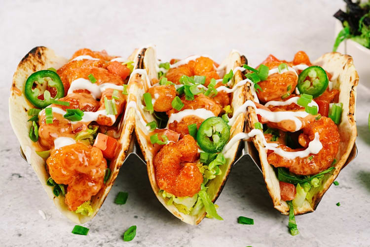 Side view of three soft-shell shrimp tacos