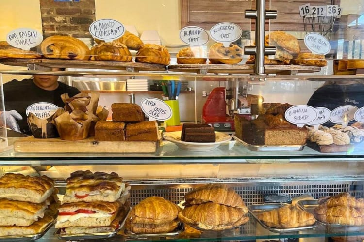 A display cabinet in a cafe with pastries and sandwiches