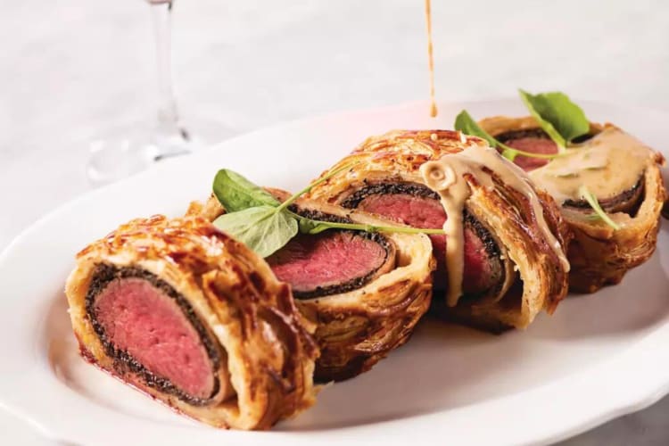 Sauce dripping over slices of beef Wellington, from Bardot Brasserie