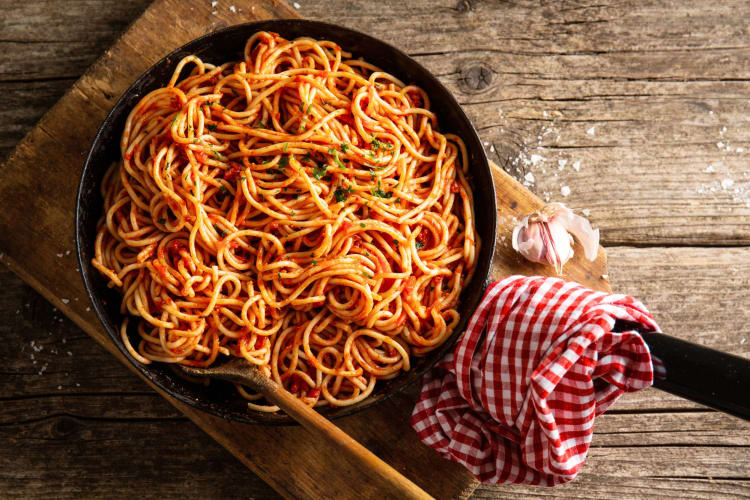 A cast iron pan with tomato spaghetti
