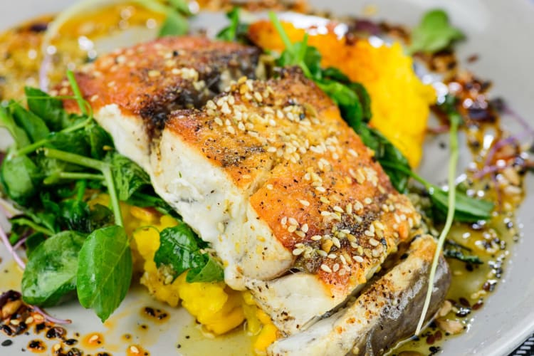 A filet of barramundi sprinkled with sesame seeds.