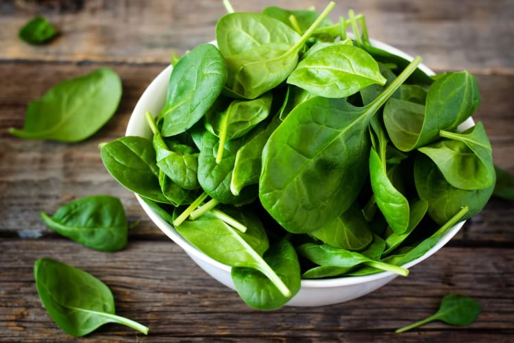 A wooden bowl with spinach