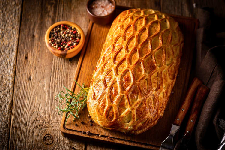 Homemade pastry beef Wellington on a wooden table.