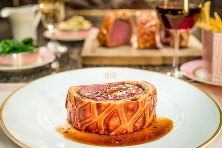A plate with beef Wellington, covered in gravy.