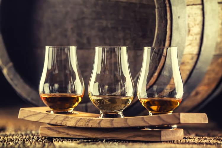 Glasses for whiskey tasting next to a barrel