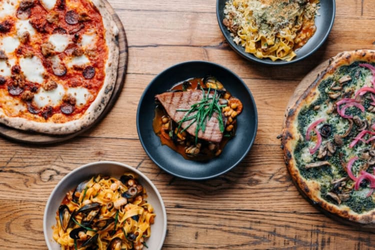 A selection of pizzas and some other dishes on a table
