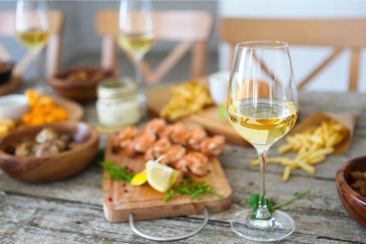 A glass of sauvingon blanc on a table next to food