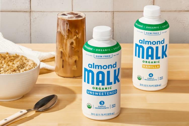 Bottles of almond milk, cereal and an iced coffee on a table 
