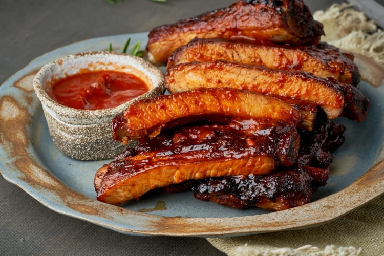 A plate of ribs with barbecue sauce