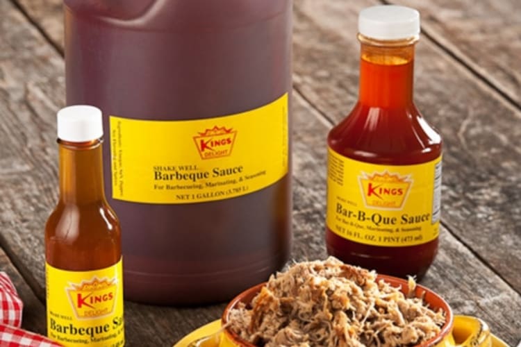 Bottles of barbecue sauce next to pulled pork
