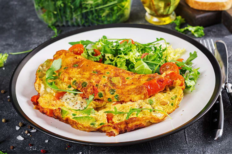 An omelette on a plate with salad