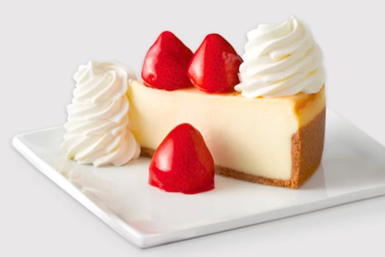 A slice of plain cheesecake with glazed strawberries