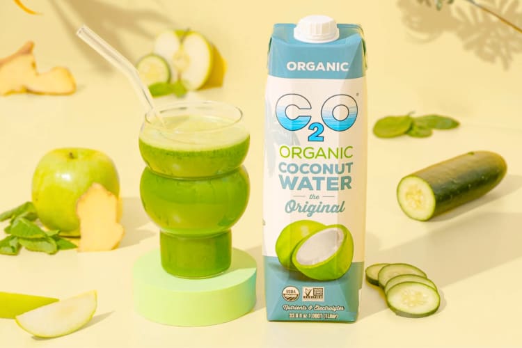 Coconut water next to a green smoothies and green salad vegetables
