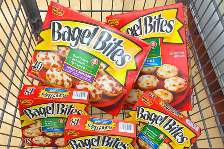 A shopping cart with boxes of Bagel Bites 