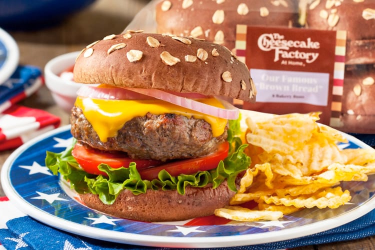 A hamburger from Cheesecake Factory on a plate with potato chips