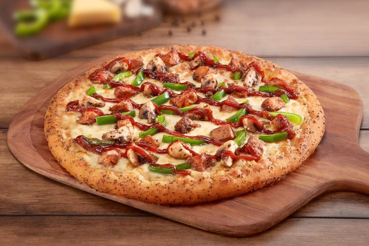 A pizza with chicken, mushrooms, green pepper and barbecue sauce