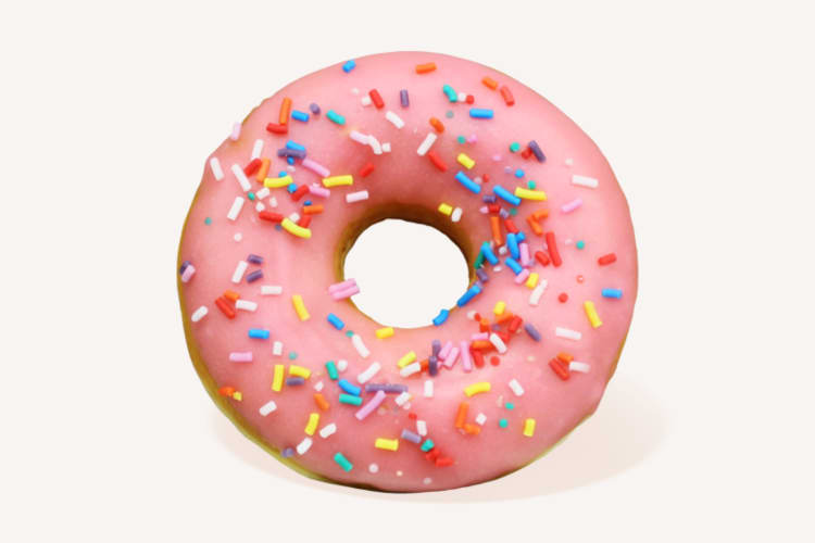 A pink frosted donut with colorful sprinkles
