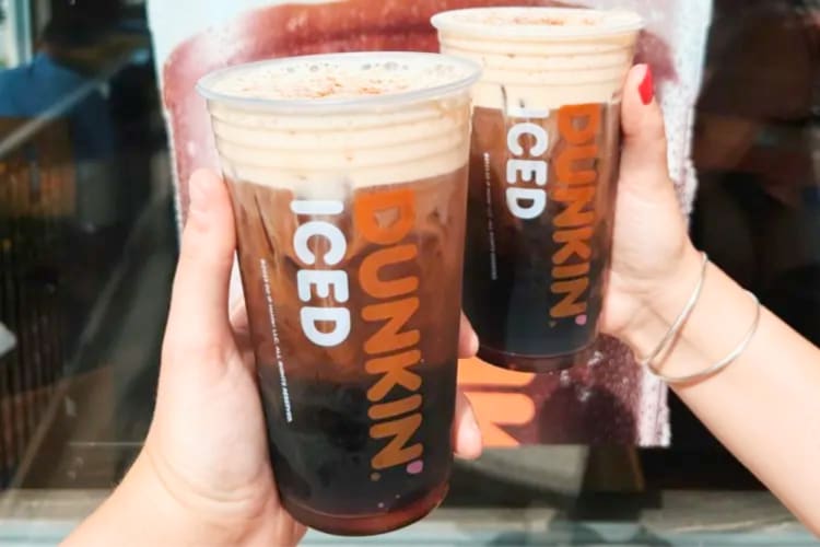 Two people holding Dunkin' Donuts iced coffee drinks