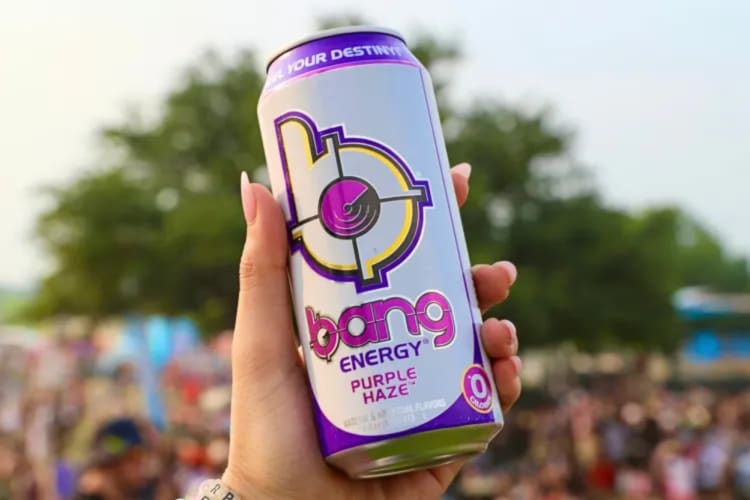 A person holding a white and purple bang energy drink