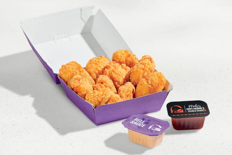 Chicken nuggets in a purple box next to dipping sauces